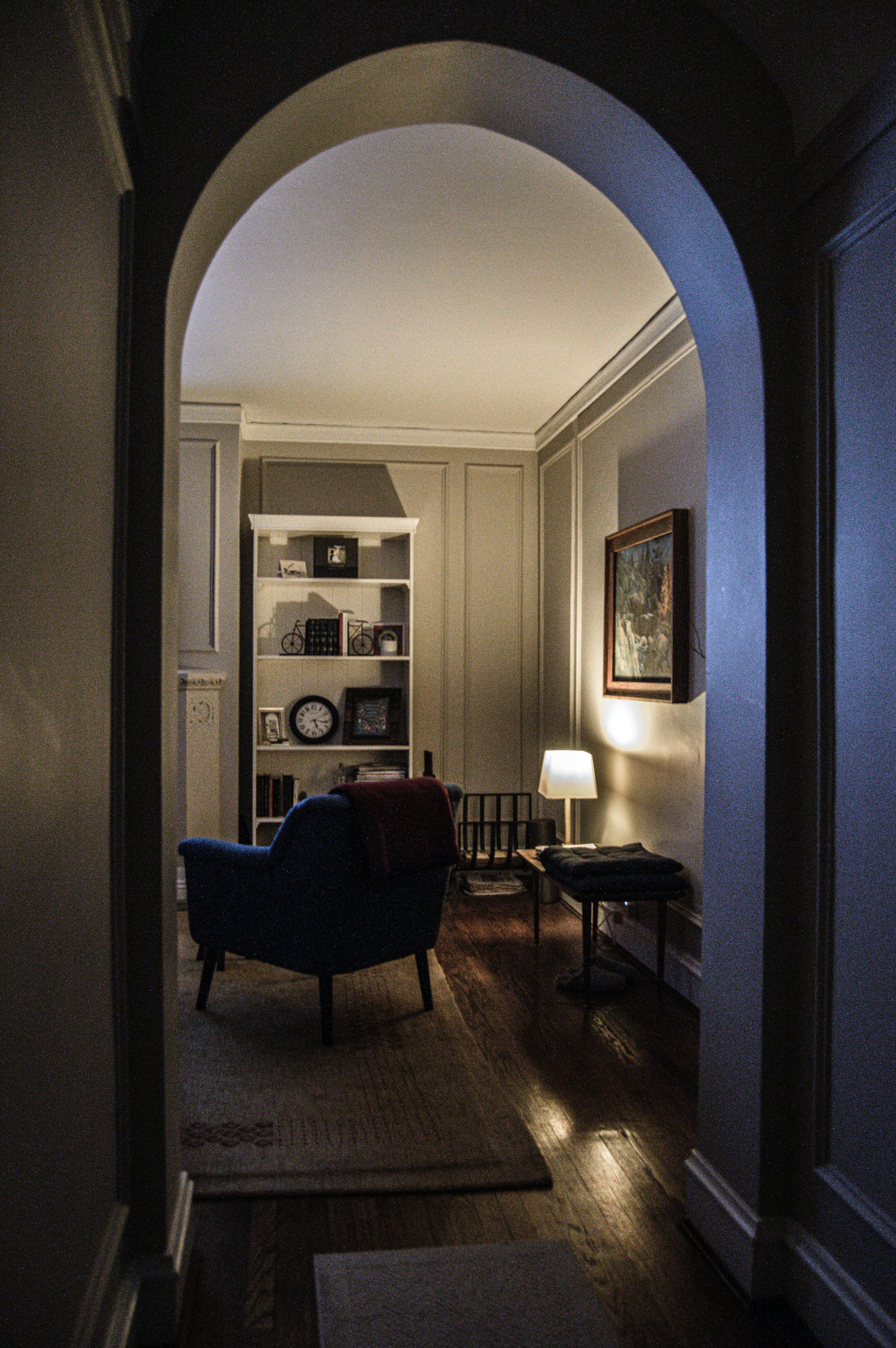 black wooden framed blue padded armchair beside brown wooden table