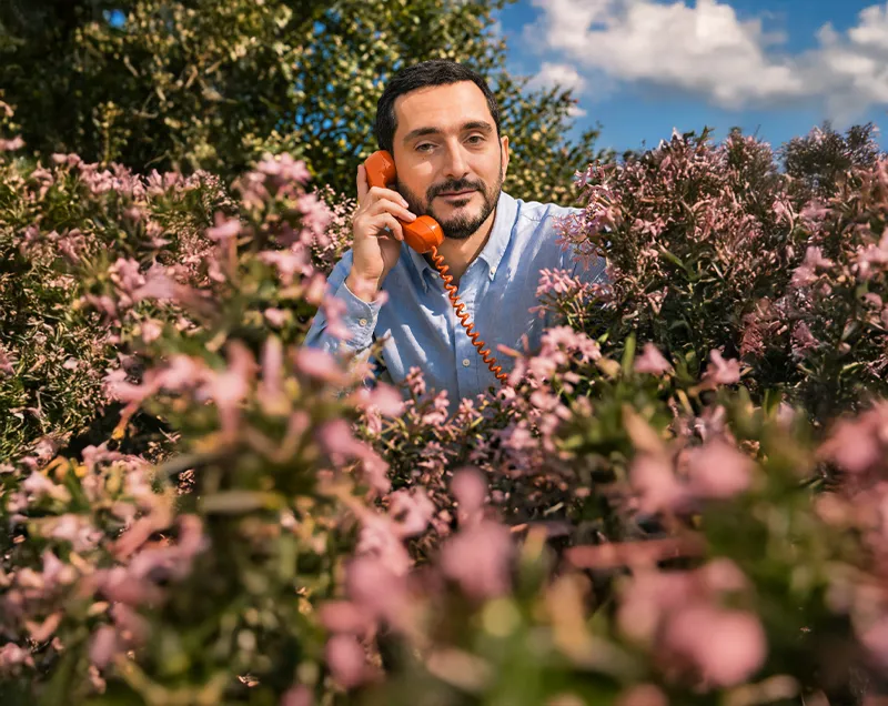 Close-up of a yellow tennis ball sitting on a green court, positioned near the white center line.