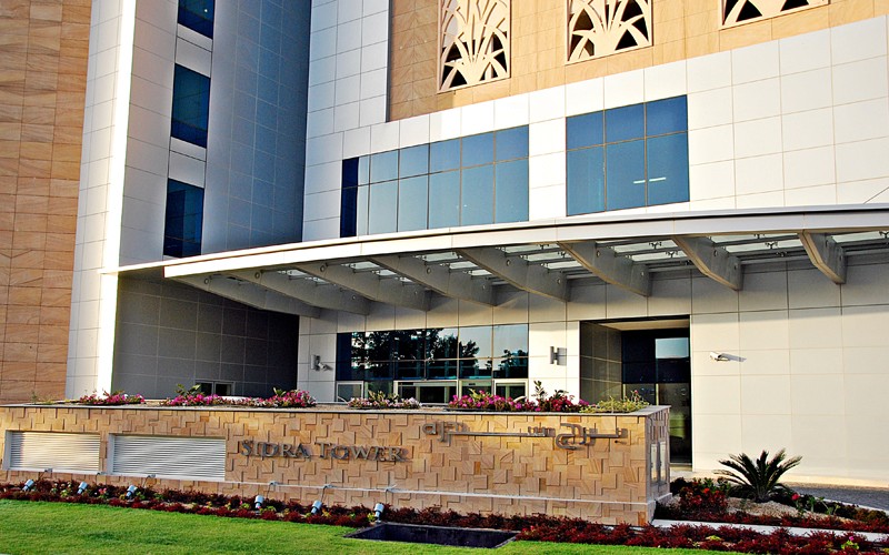 Main entrance of Sidra Tower with elegant landscaping and stone signage for a premium business address.