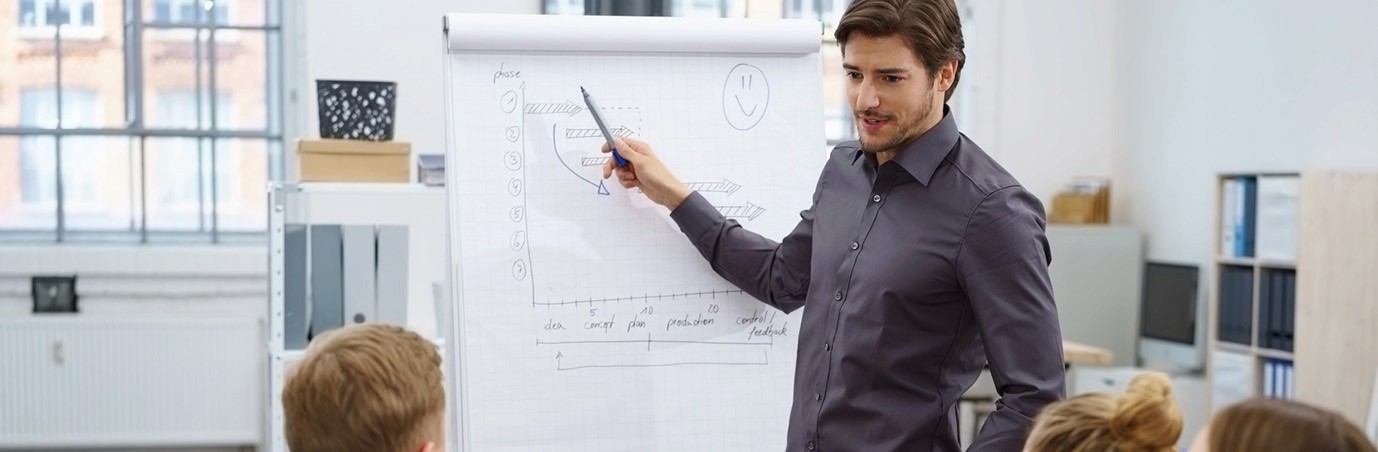 Young man stand next to a slide giving a presentation