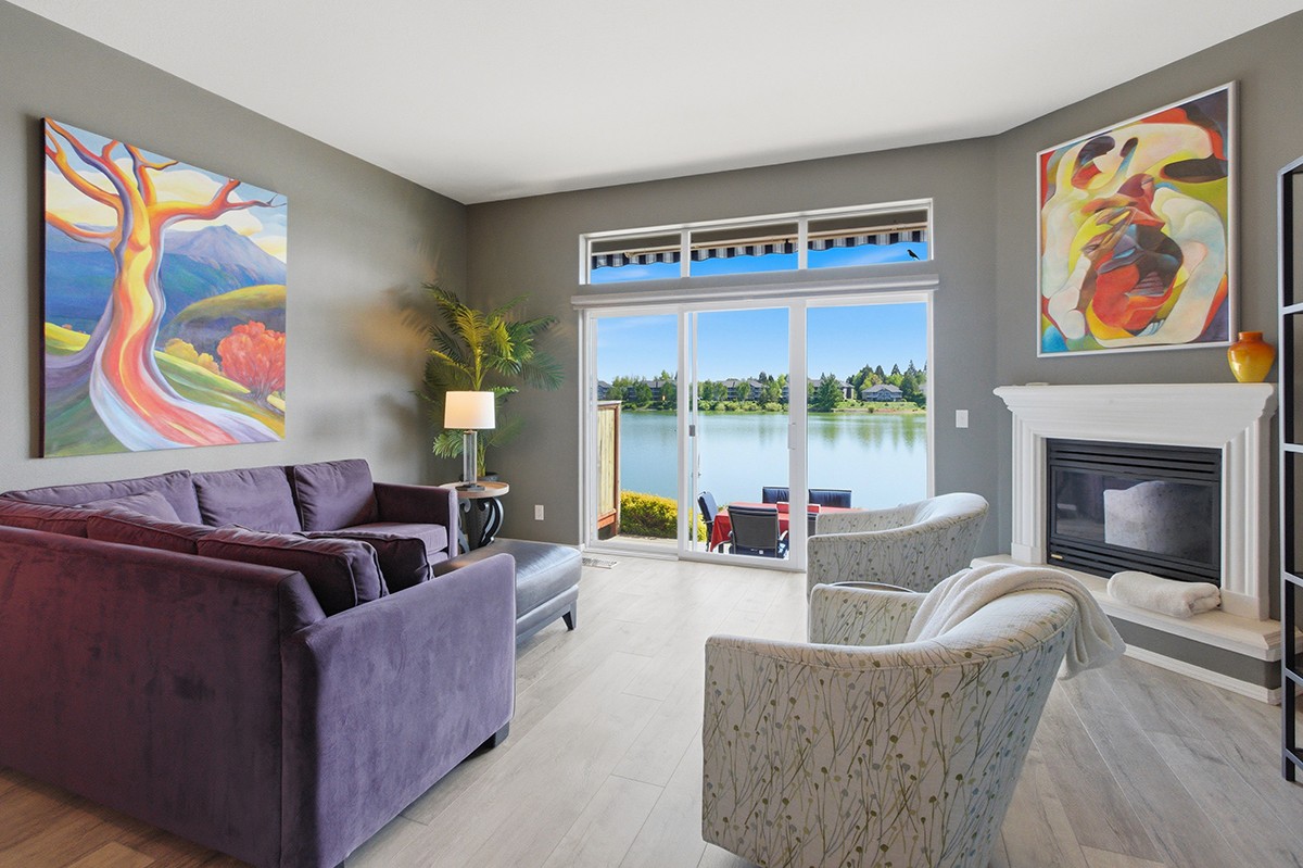Hyperreal professional real estate photograph of a classy decorated living room and lake outside through windows