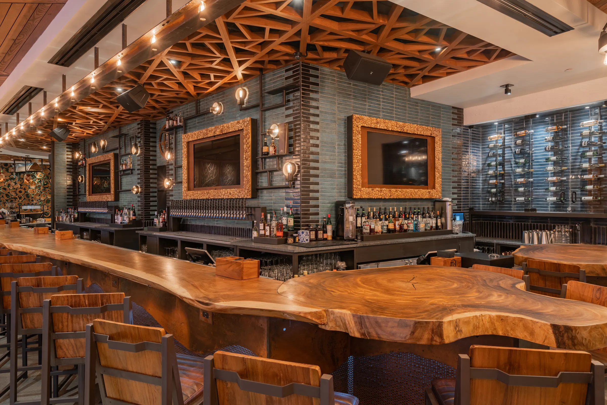Live-edge wood bar with green tile back bar at TownHall Columbus