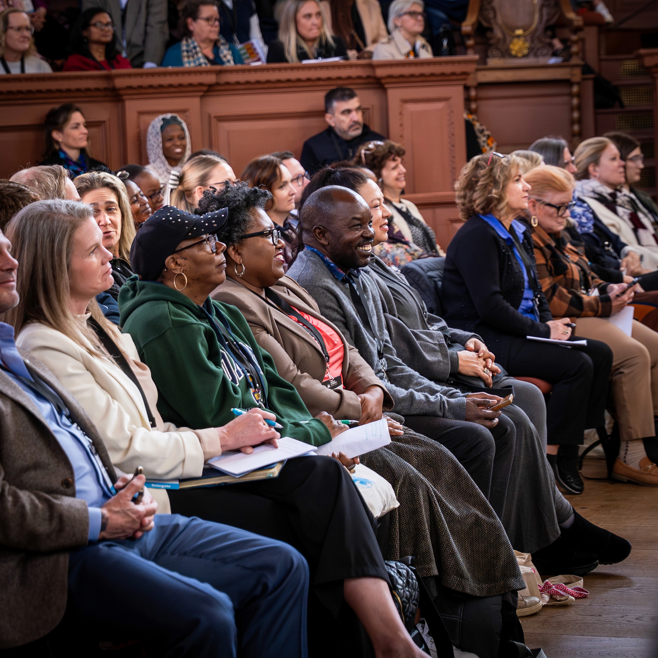 Speakers and attendees at an AI conference, featuring a keynote presentation and networking between product and tech teams.