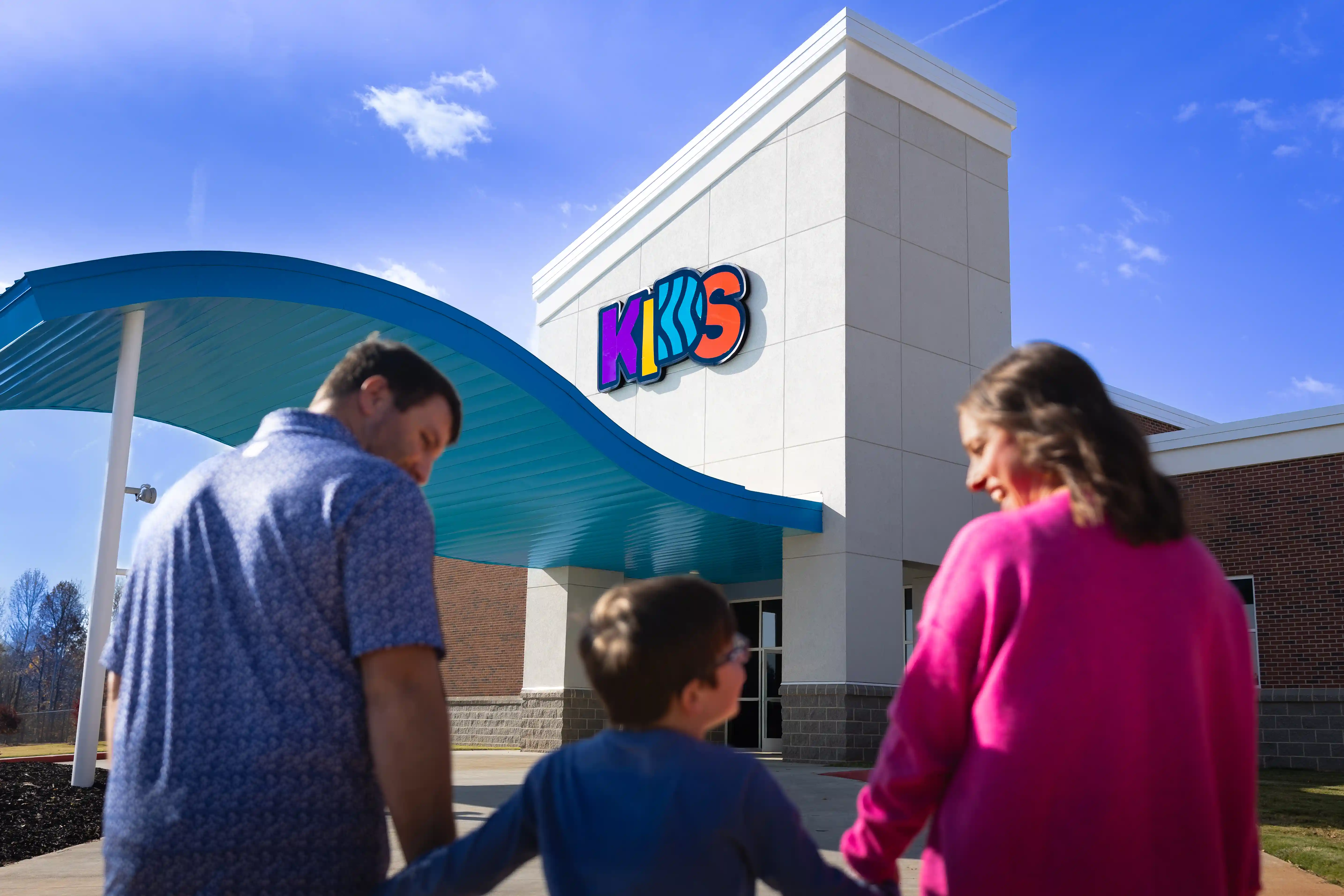 Young Family walking into Kids Building