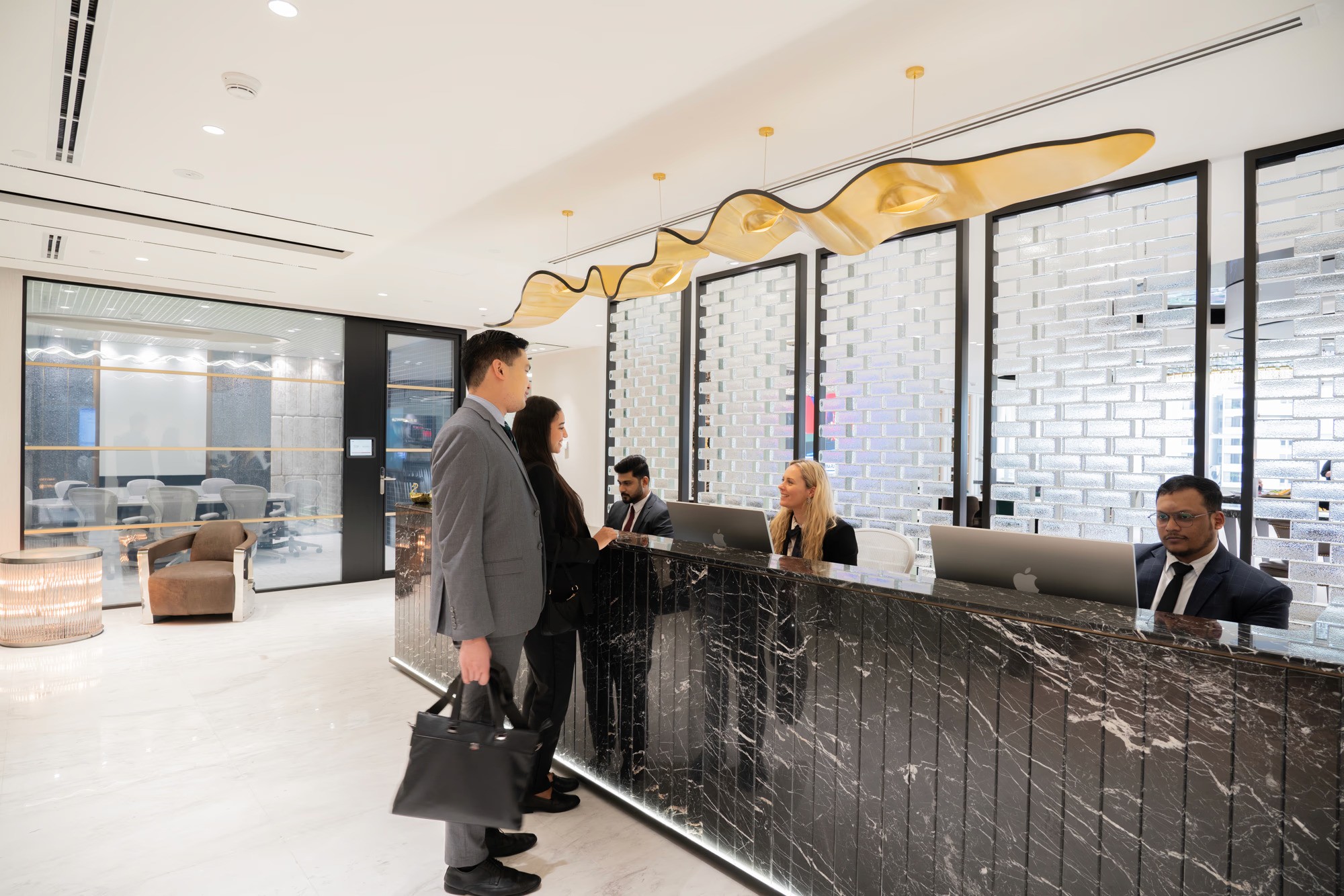 منطقة استقبال فاخرة تضم موظفين يقدمون المساعدة لرجال أعمال يستفسر اصدار رخصة تجارية دبي  .