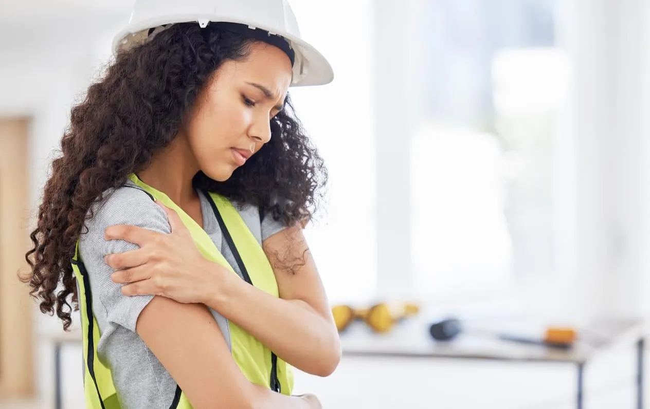 mujer trabajadora de la construcción y lesión en el hombro - lesión en el lugar de trabajo