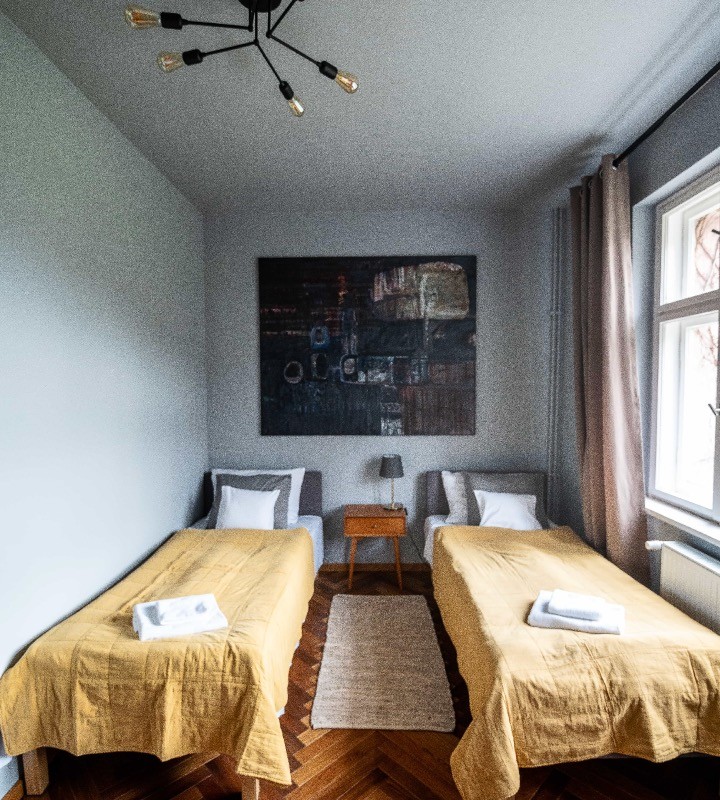 Dwa łóżka pojedyńcze i piękny obraz w apartamencie w Villi Stara Apteka. Hotel dla grup jogowych na Dolnym Śląsku w Srebrnej Górze