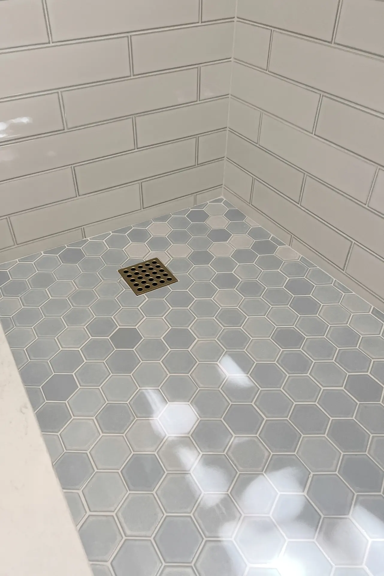 Close-up view of the shower pan and wall tile in the guest bathroom, showcasing tile details and design in the Irvine Contemporary Coastal Remodel. Photo by Todd Huge