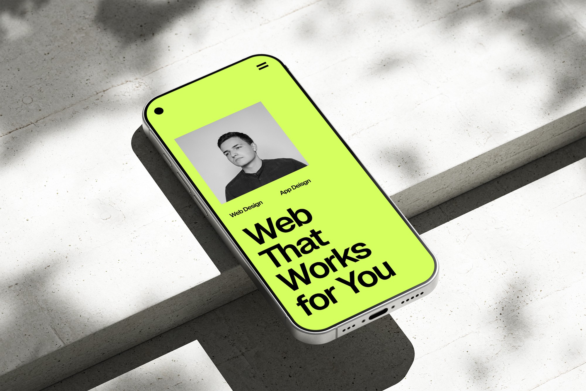 Phone on concrete, website on screen