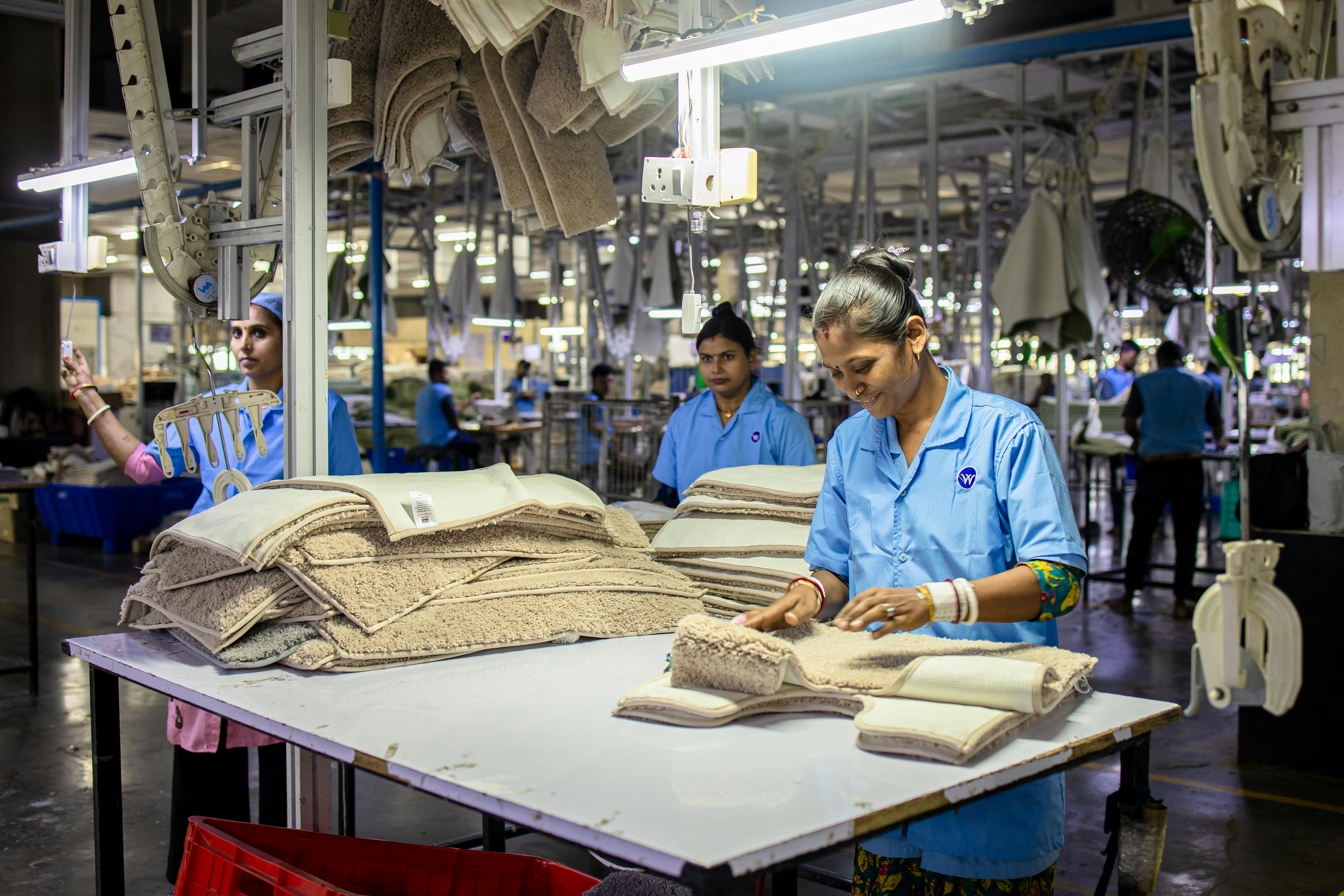 Workers are folding textiles in a factory.
