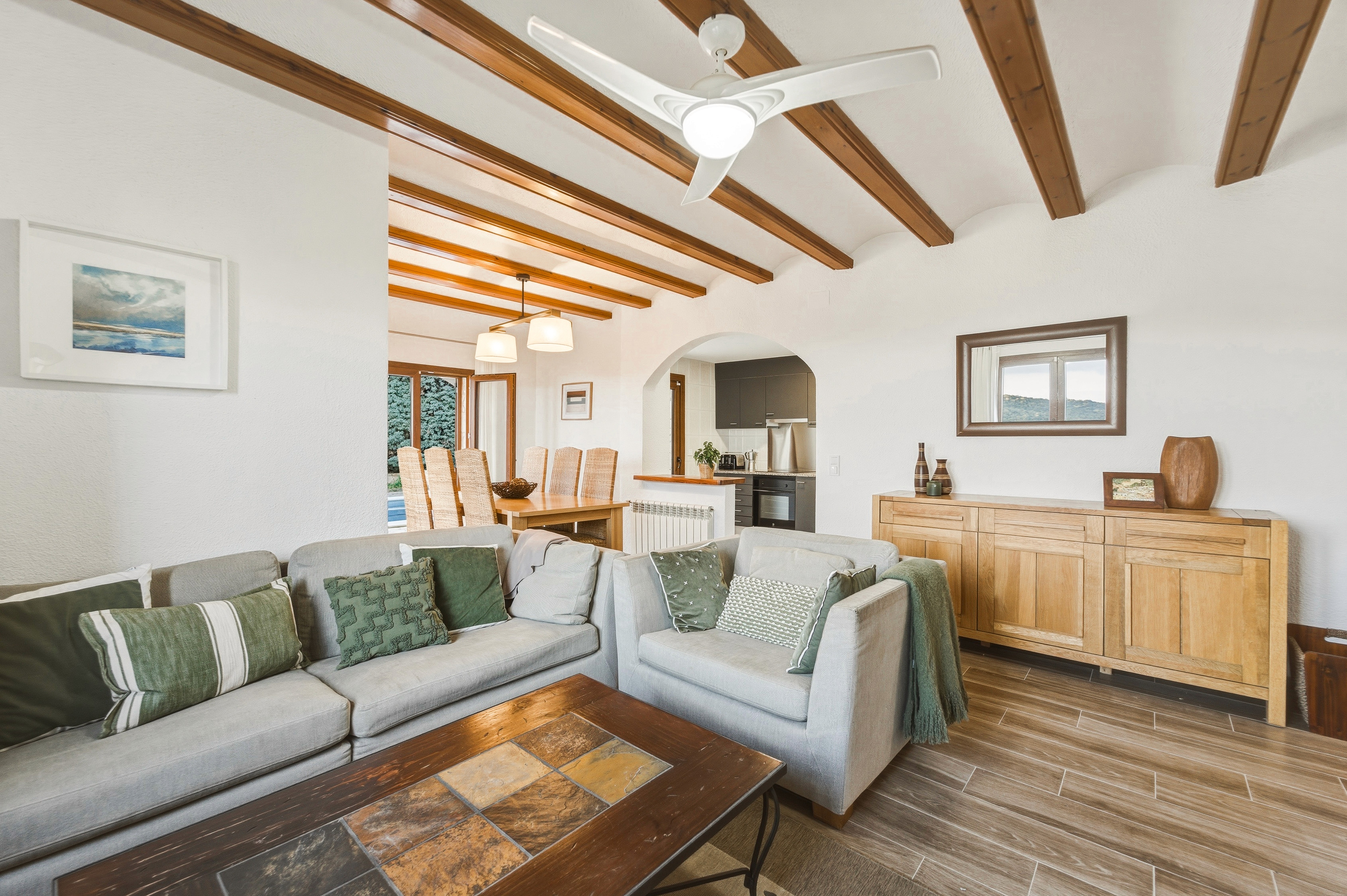 Terraza cubierta amplia con mesa de comedor y vistas panorámicas a las montañas y al valle, fotografía profesional de inmueble.