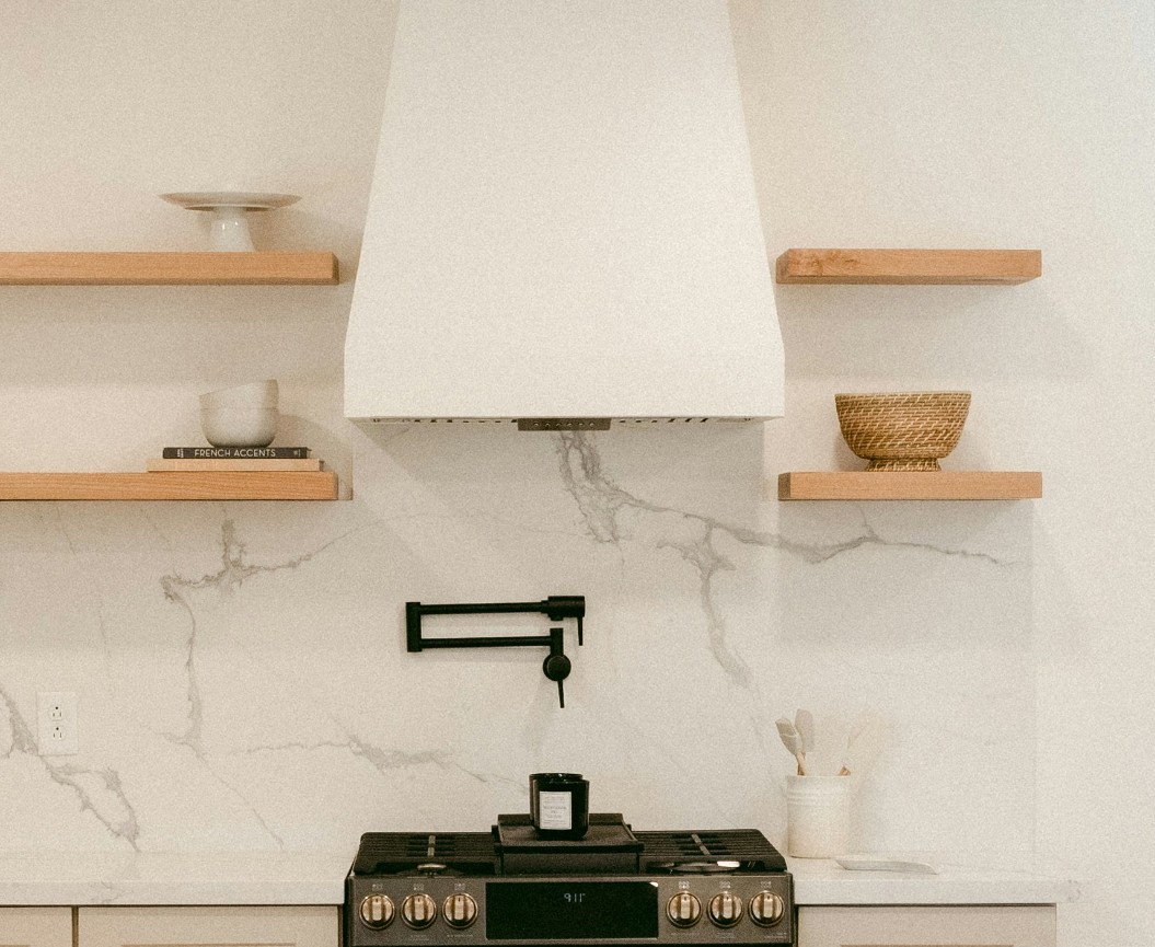 plaster vent hood with open shelves left and right of stove