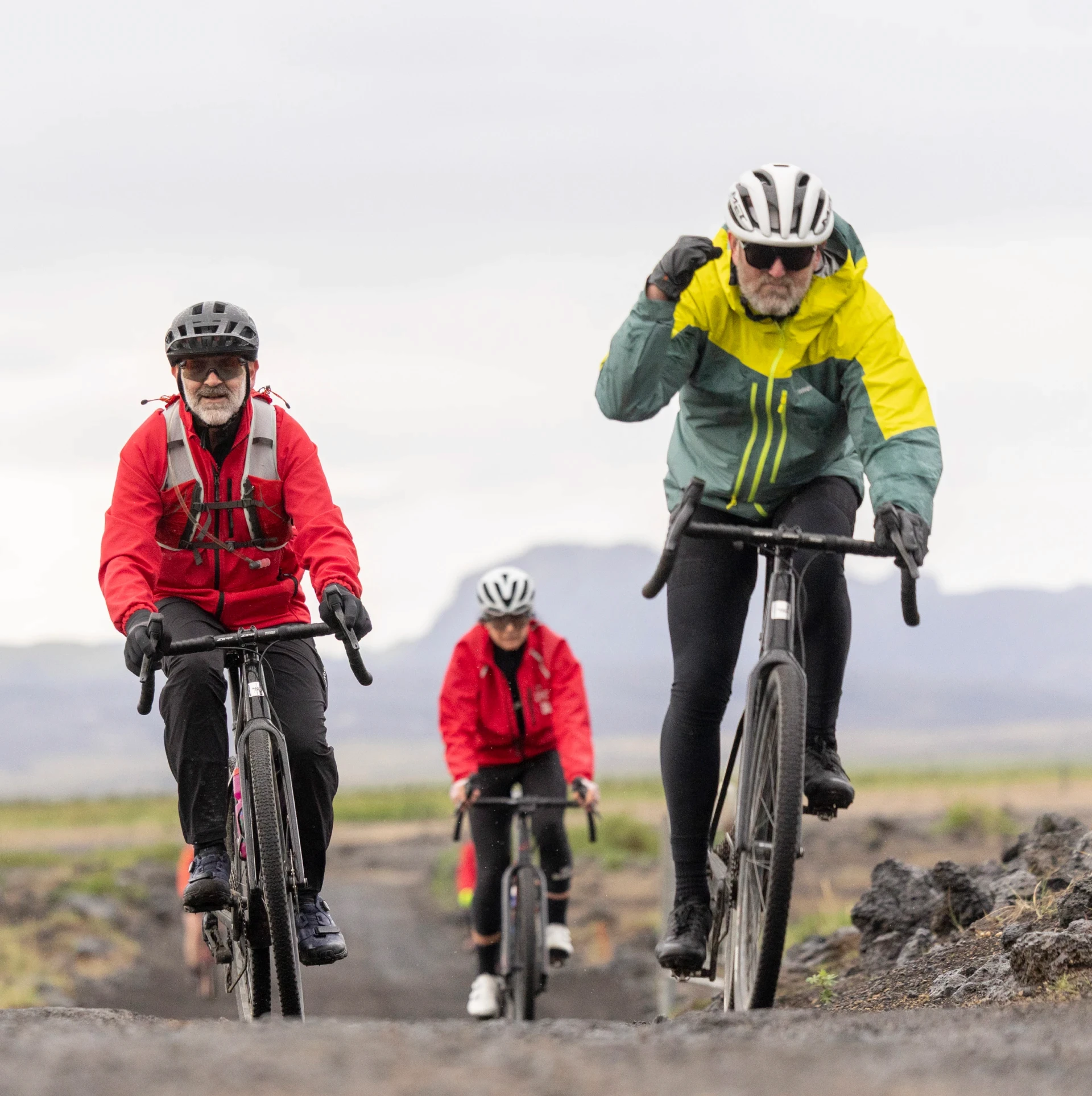 three men bike towards camera