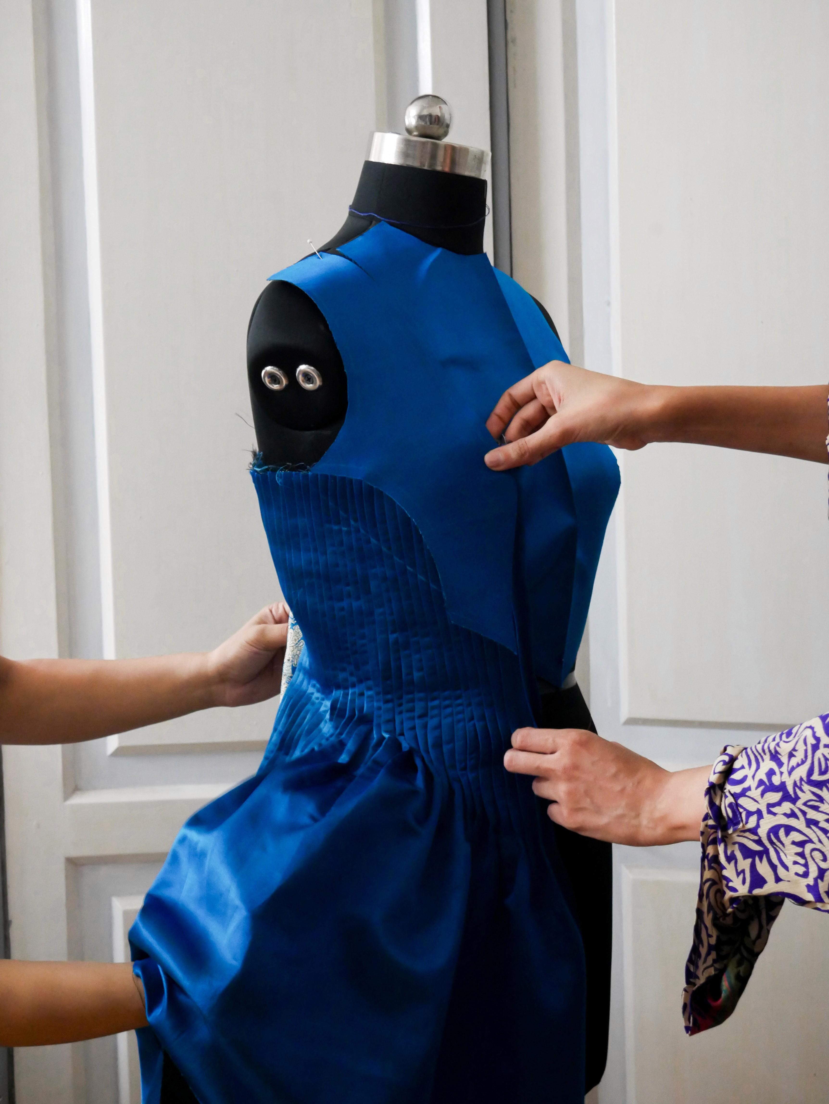 Woman in white sweater posing against wood wall