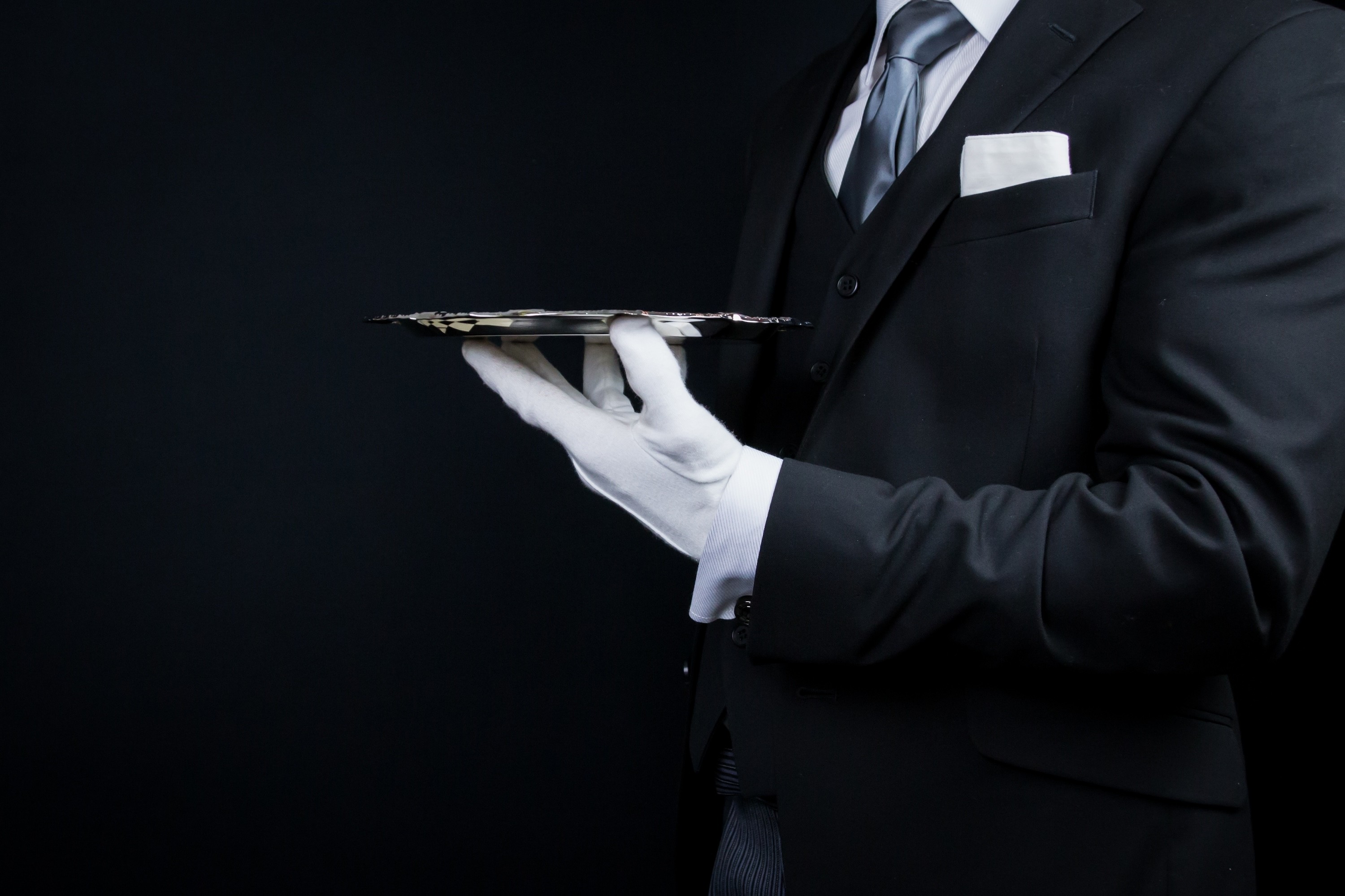 Person working on a laptop at a wooden table with documents, a glass of juice, and a plate of toast
