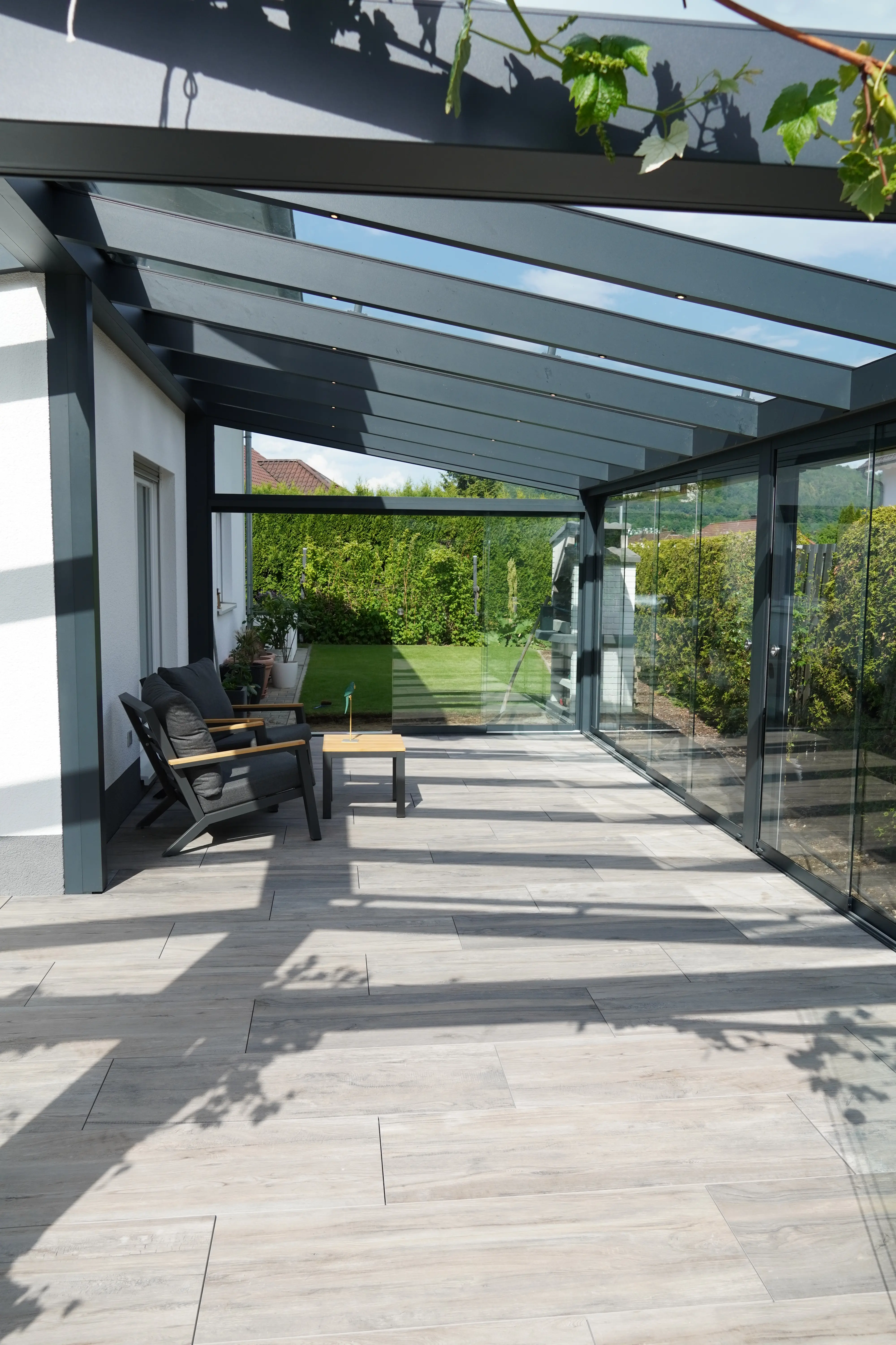 Terrassenverglasung mit Glasschiebeelementen und Glasdach als Sommergarten