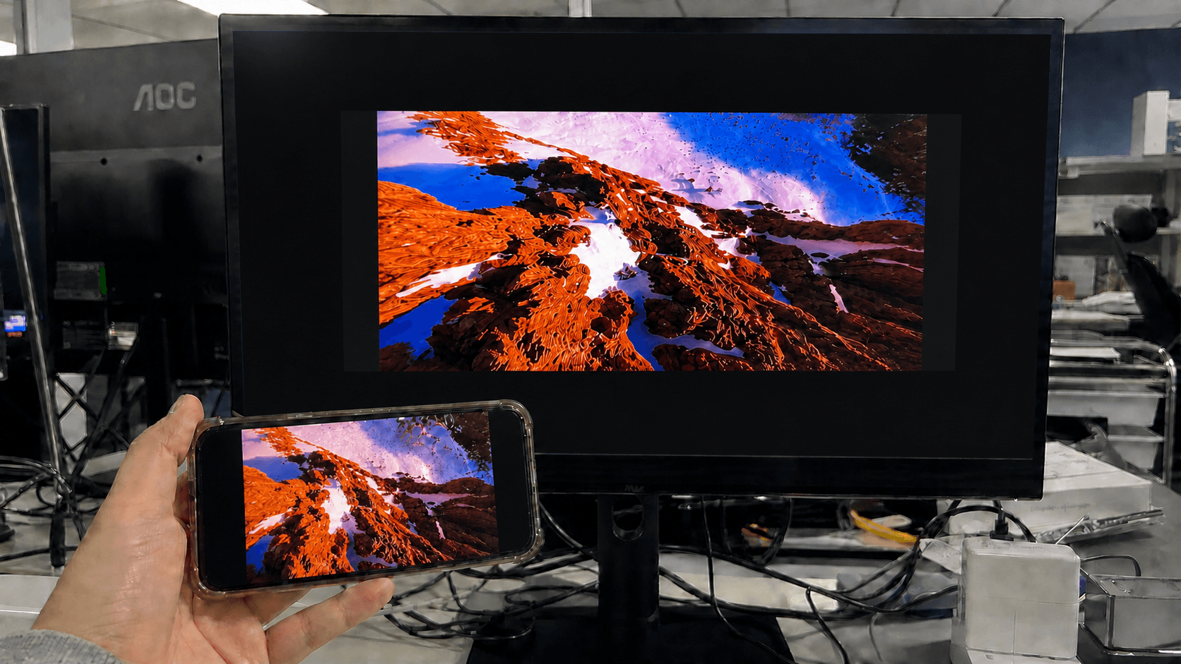 A real-world test photo of AirDroid Cast mirroring a phone screen to a laptop, captured during hands-on testing with visible device setup and mirrored display quality.