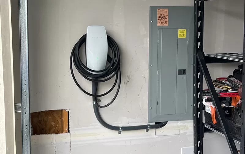 EV charger installed beside a garage electrical panel