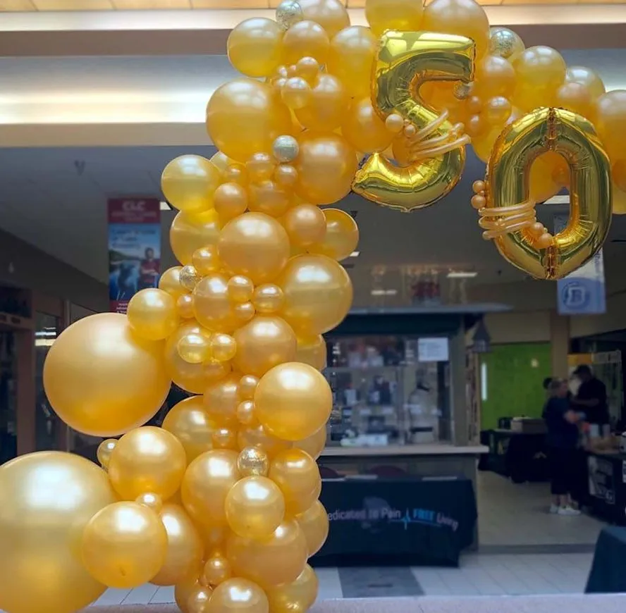 Gold balloon arch with metallic accents arranged for an elegant indoor event by Be Bold Balloons