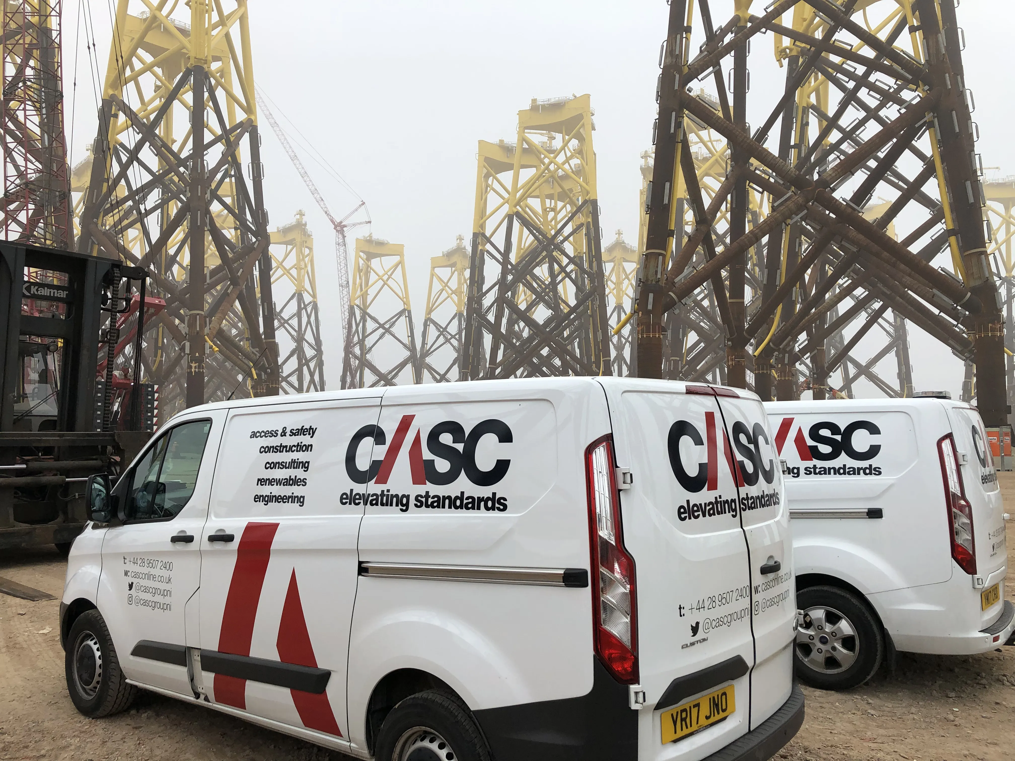 CASC vans parked on site in front of offshore wind foundation structures during project delivery operations.