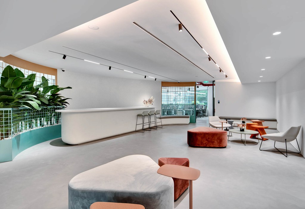 A chic office environment at The Binary by Omniyat, complete with a bar area and decorative plants.