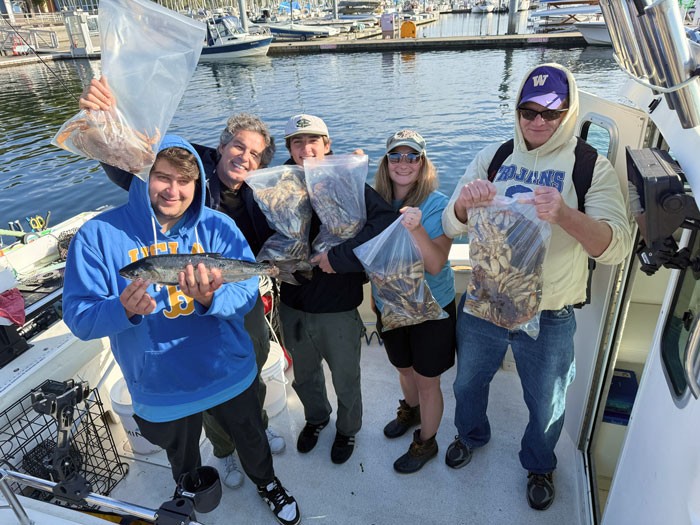 friends and family holding dungeness crab at a seattle fishing charter boat