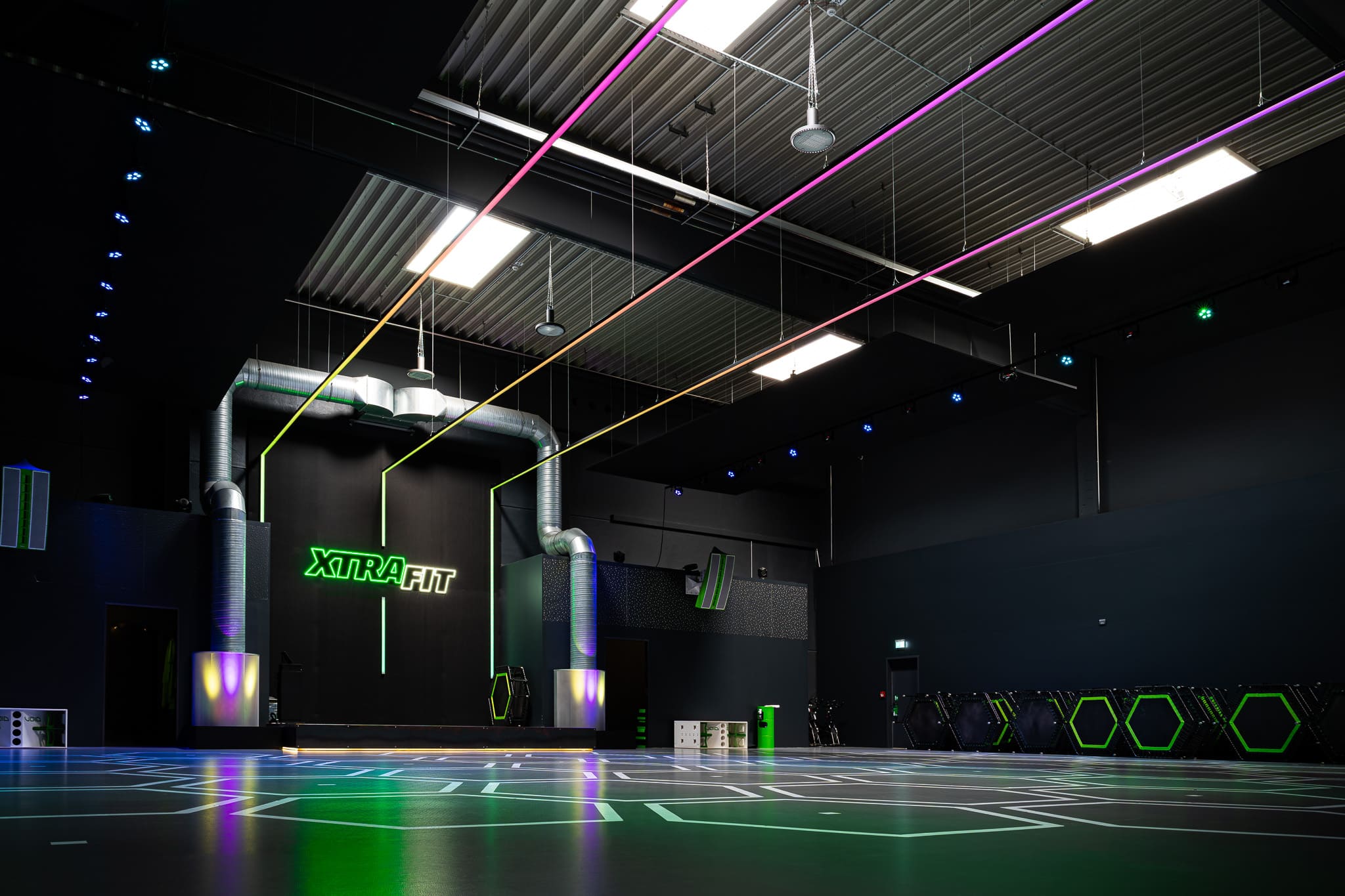 Der bunt beleuchtete und große Kursraum im XTRAFIT-Studio in Essen.