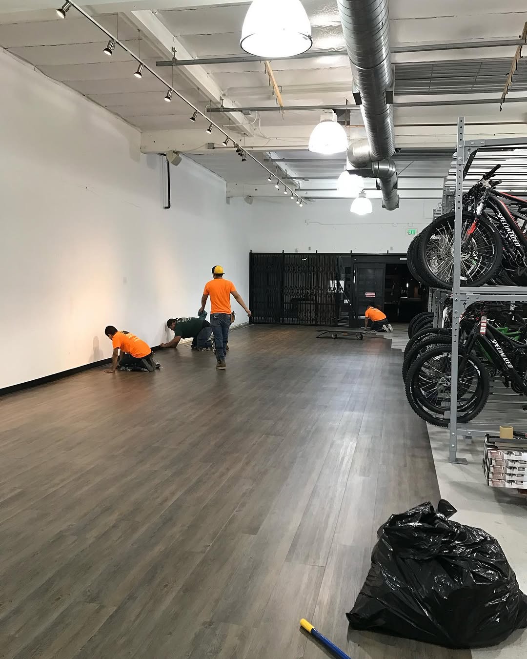 Finished floating LVT retail floor with the crew cleaning up