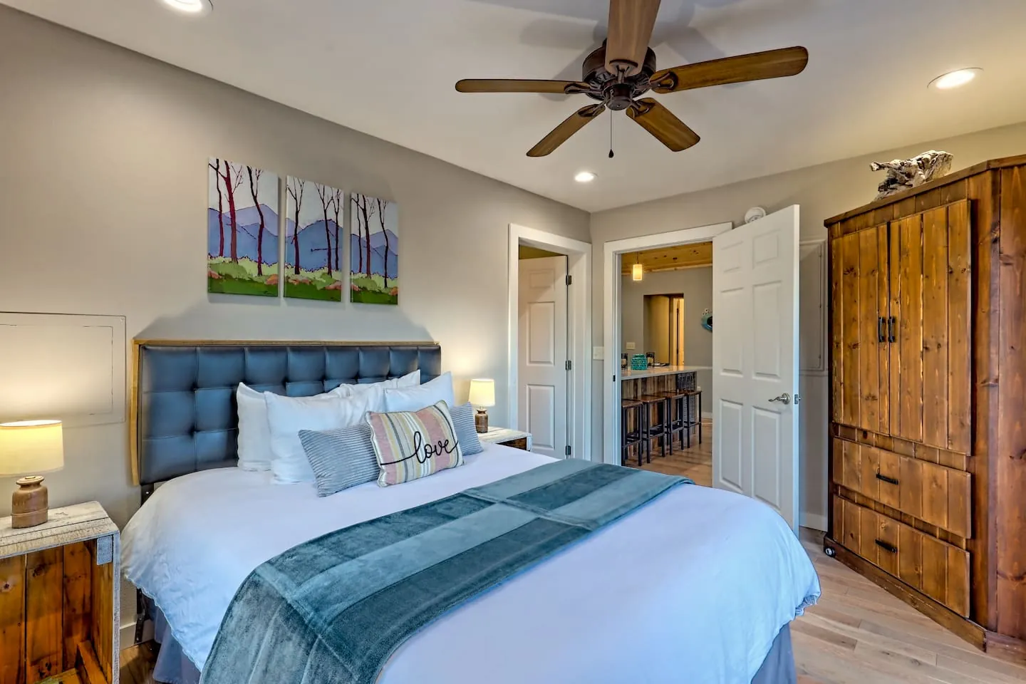 Eagles Nest queen bedroom with a tufted headboard and a rustic wood armoire