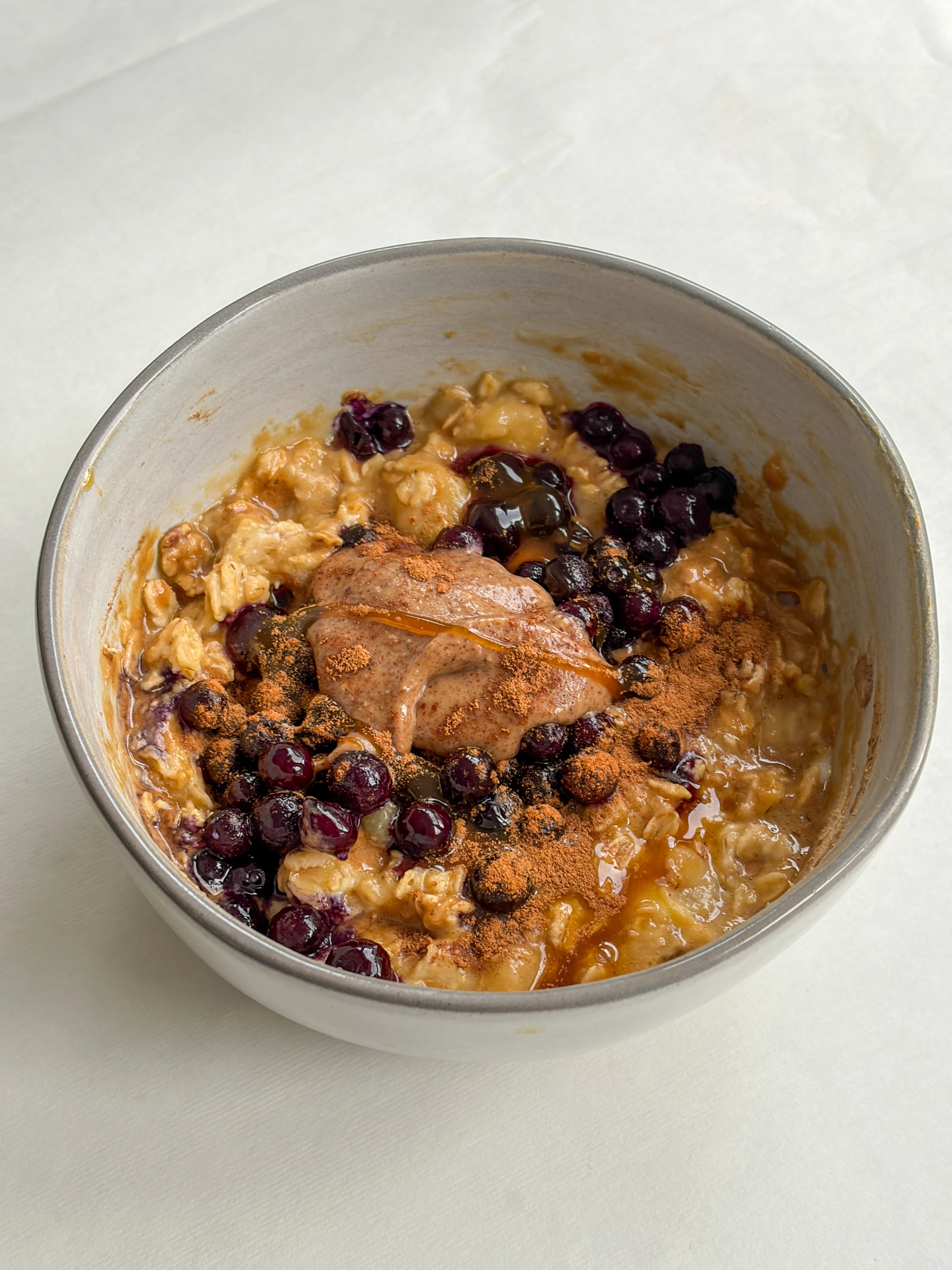 High-protein vanilla blueberry oatmeal bowl with almond butter, cinnamon, and a bit of honey