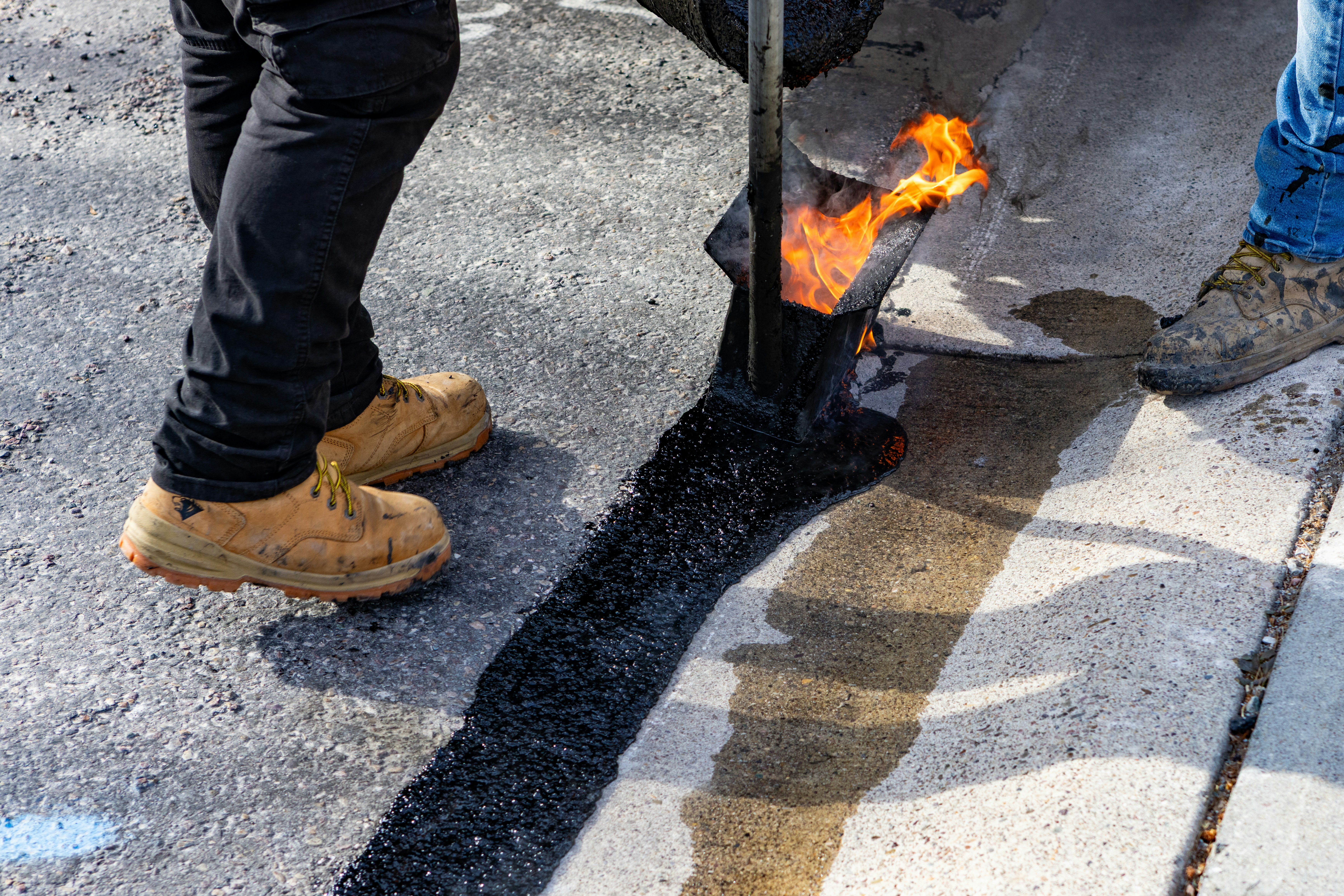 workers-applying-hot-asphalt-with-a-torch - judy-beth-morris (unsplash)./pho