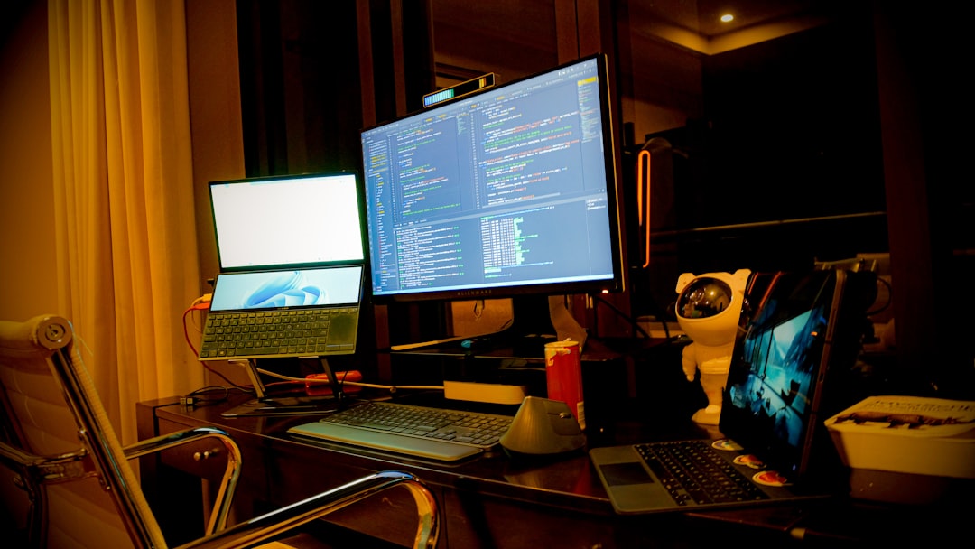 a computer desk with two monitors and a laptop
