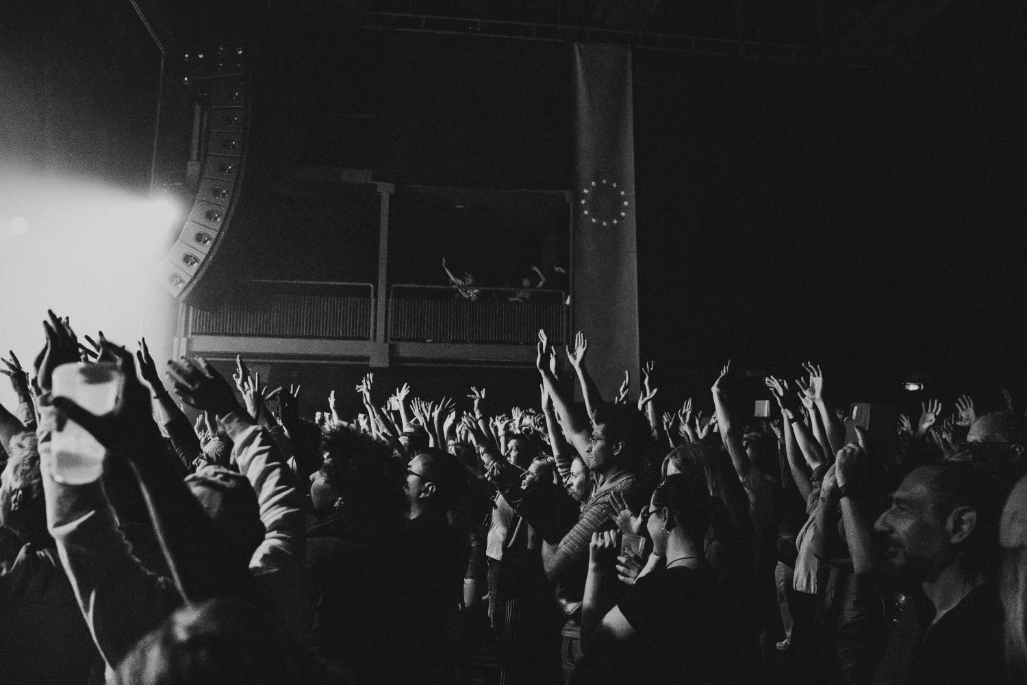 crowd lifting their hands watching concert