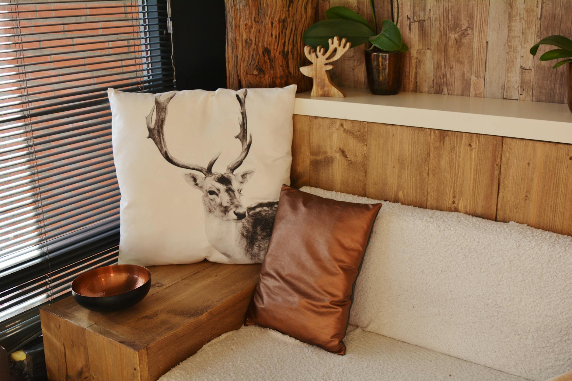 A cozy living space featuring a deer pillow, modern decor, and rustic wooden elements.