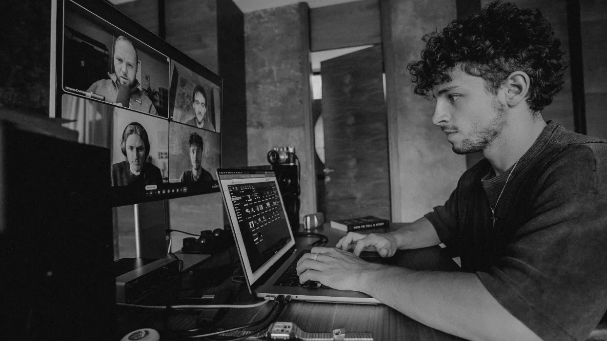 Reilin working behind his laptop while in a meeting