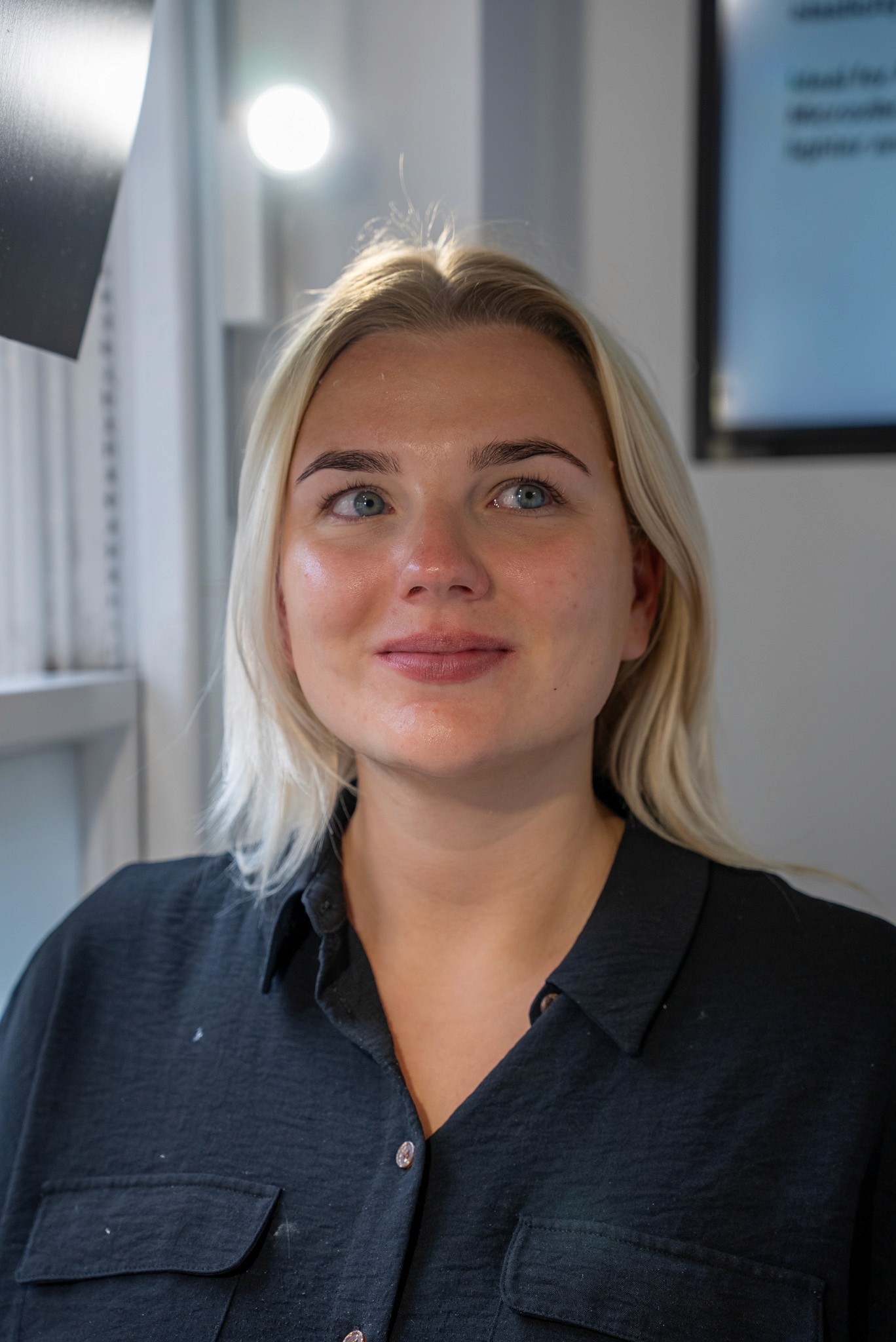 Woman with blonde hair looking up and smiling.
