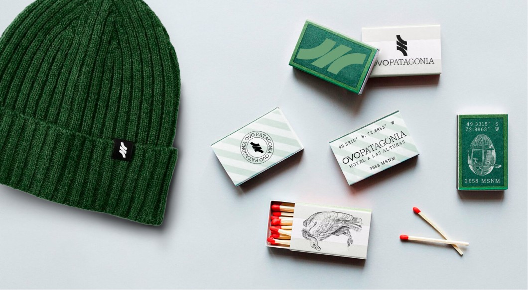 Gorro tejido verde con etiqueta de logo; alrededor, cajas de fósforos OVOPATAGONIA en tonos verde y fósforos sueltos.