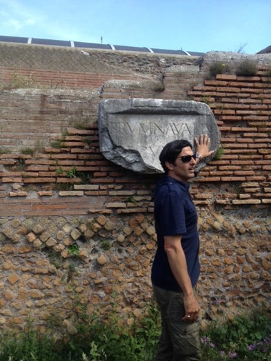 men with sunglasses touching ancient engraved stone