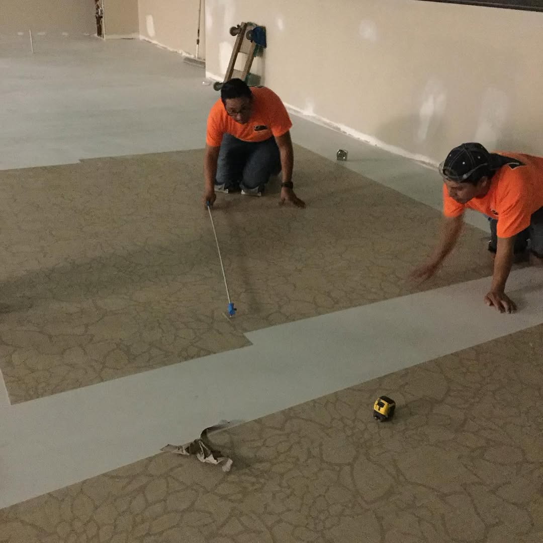 Installers measuring a sheet vinyl inlay off the centreline