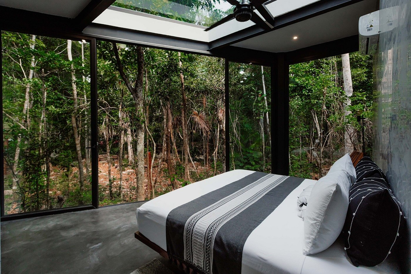 Dirt road flanked by vineyards and cypress trees, rolling hills, mist, and distant town in Tuscany.