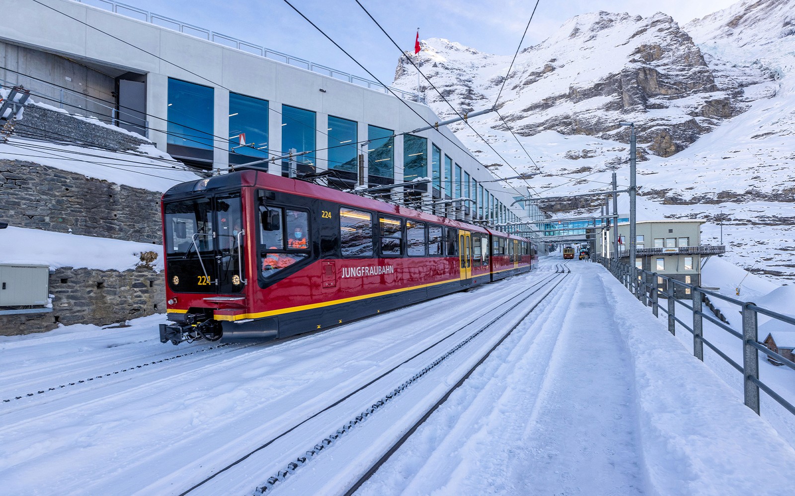 Jungfraubahn train arriving at snowy Jungfraujoch station, Switzerland.