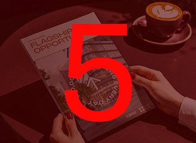 A green butterfly rests on a flower.