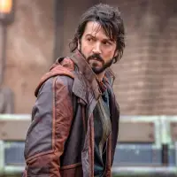 Cassian Andor looking behind him wearing a red and black jacket