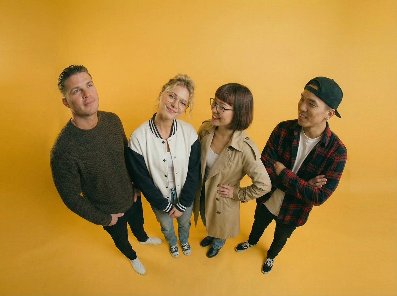 4 creative people standing on yellow background