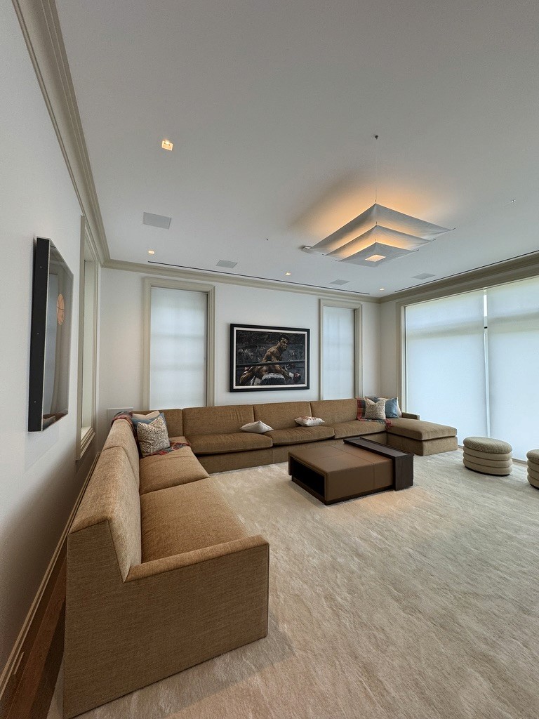 Living room with a framed boxing painting mounted above a sectional sofa