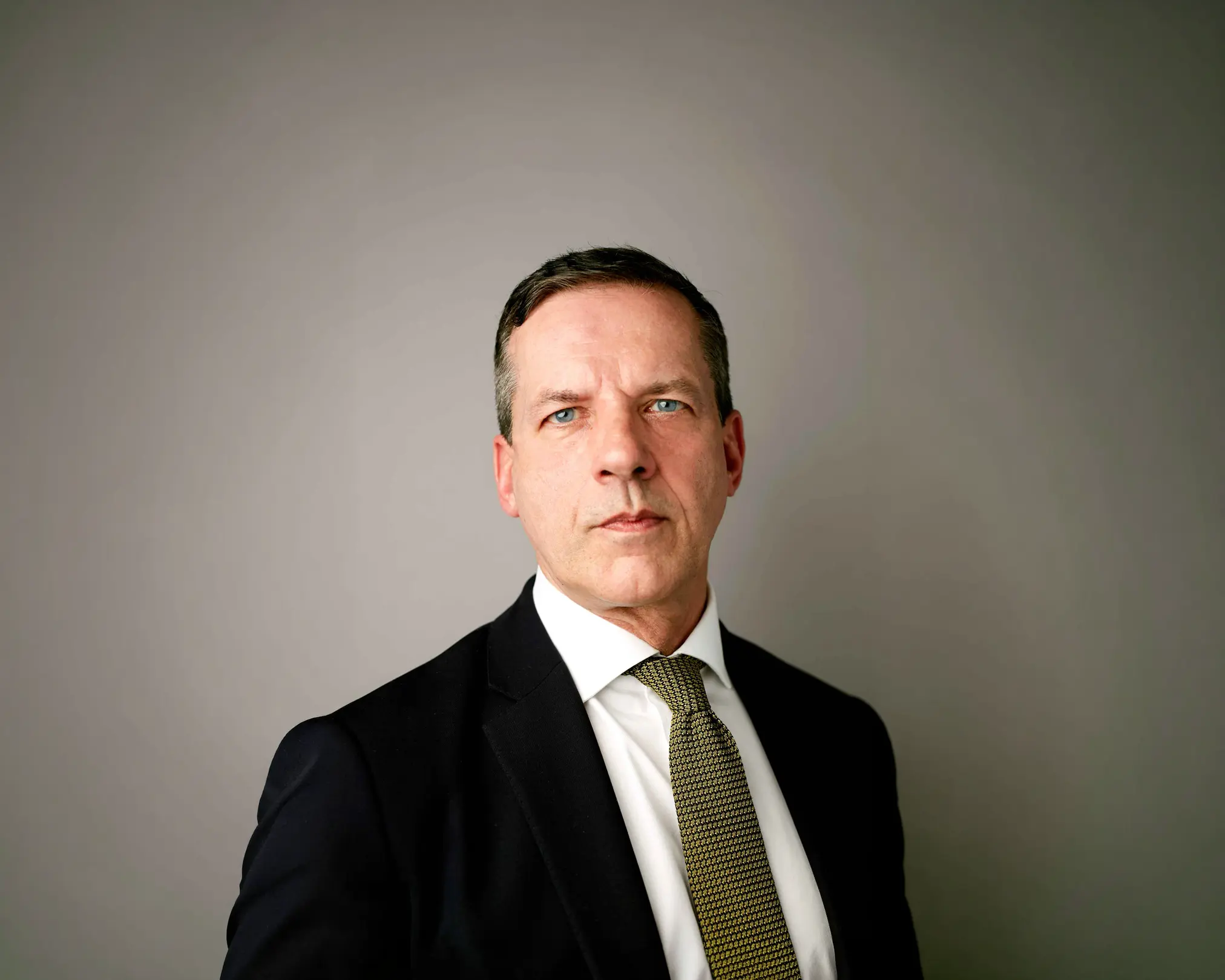 Man in suit and tie against plain background