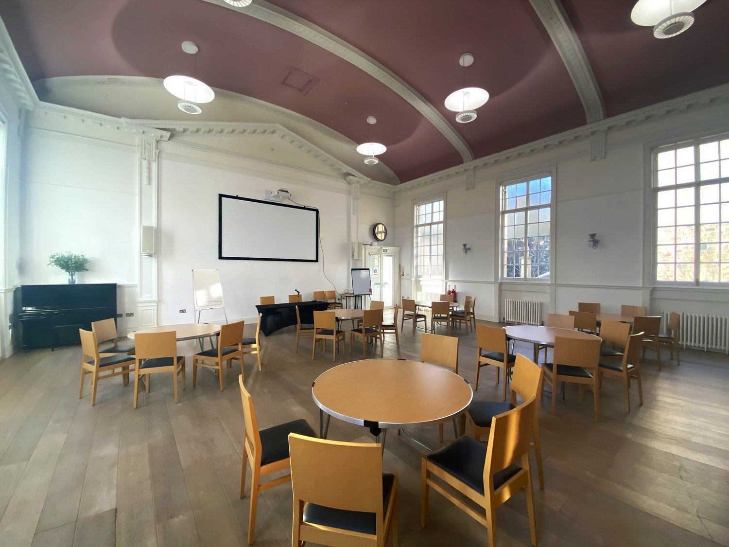 Epworth Hall set for a meeting with tables, chairs, and a projector screen