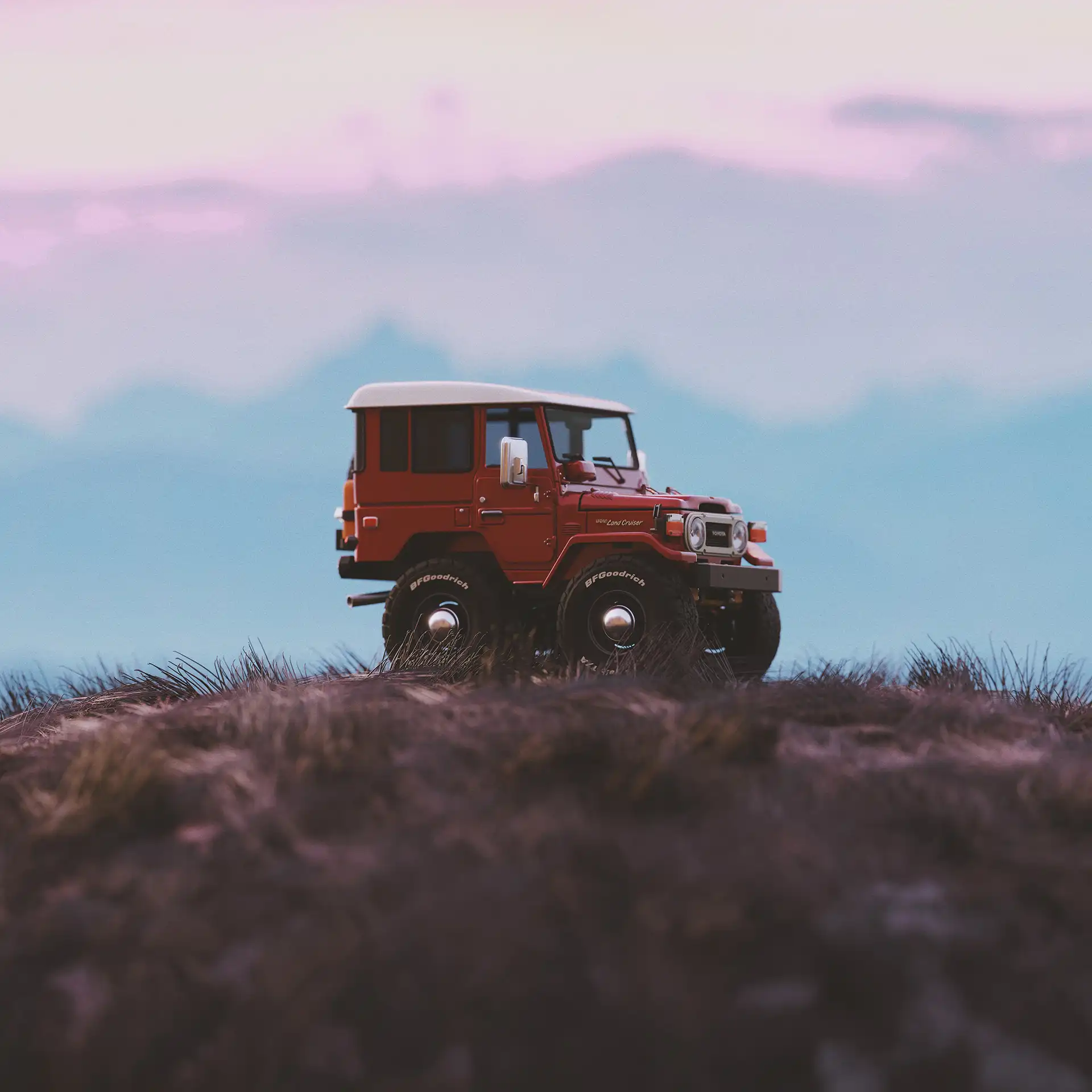 A digital rendering of a red off-road truck on a hill.
