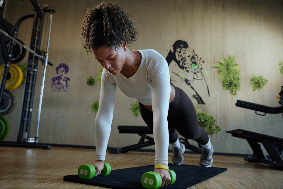 Ein weibliches XTRAFIT Mitglied im Lady Gym Bereich in einem der XTRAFIT Fitnessstudios in Deutschland führt eine der Grundbewegungen von Calisthenics aus: die Push-Ups.