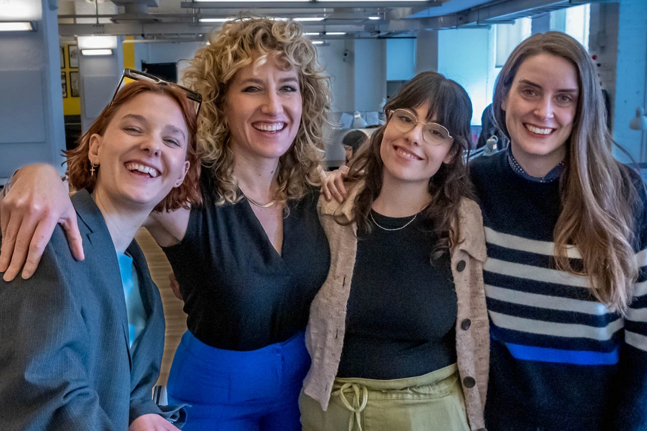 four people smiling and looking at the camera